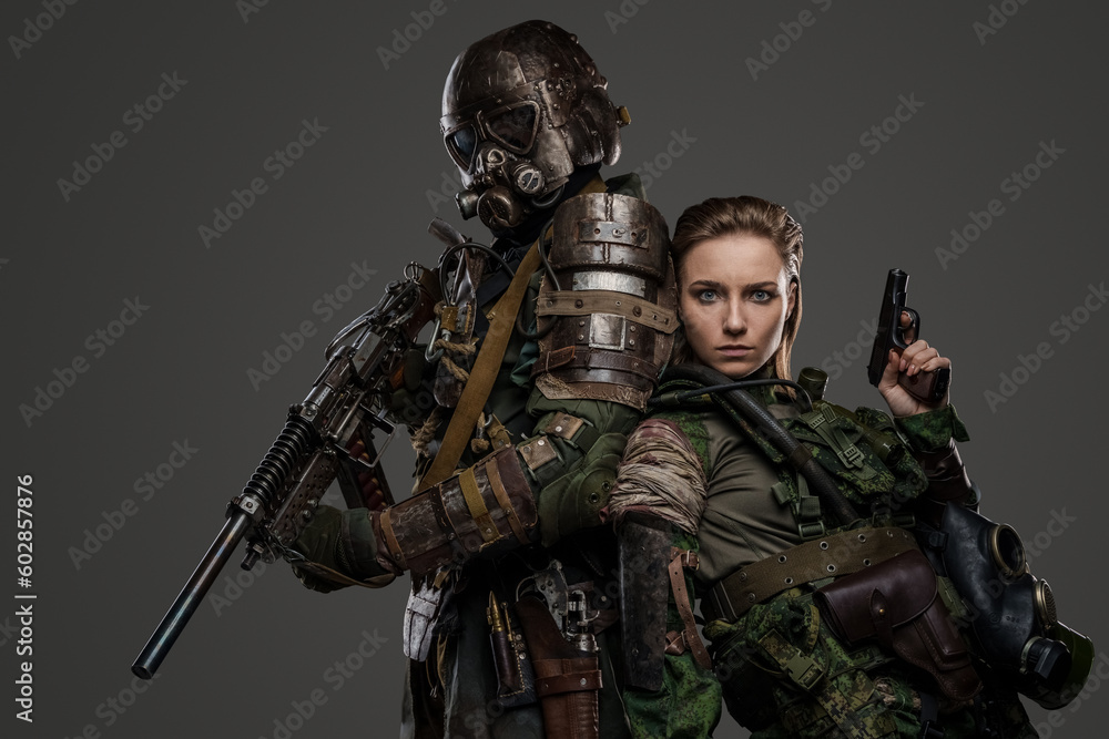 Studio shot of two female and male soldiers staying back to back with pistol and shotgun. Studio shot of two female and male soldiers staying back to back with pistol and shotgun.