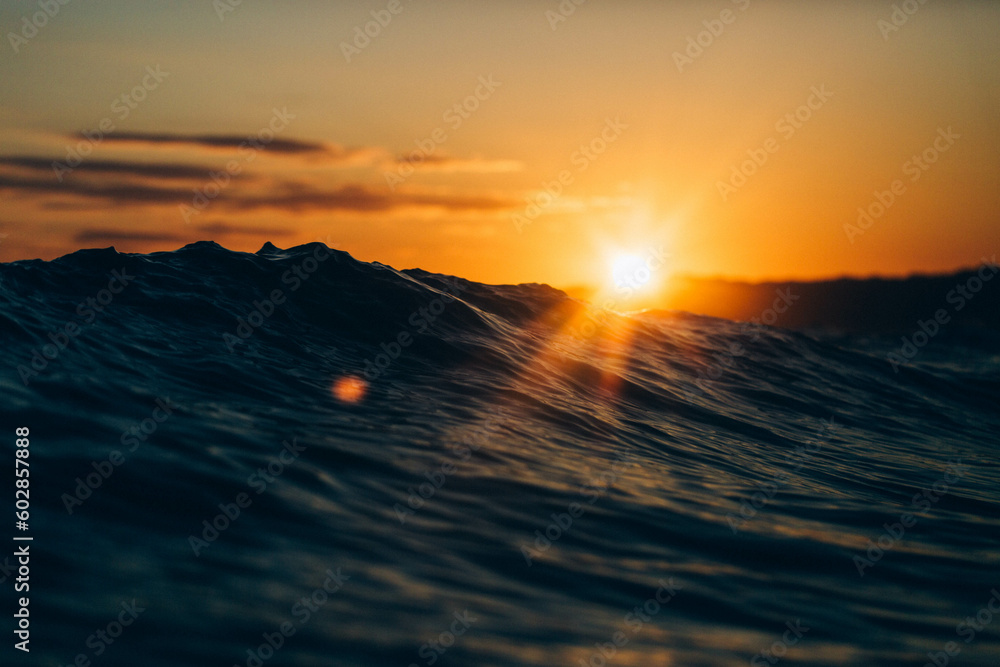 Sunrise behind the waves in St Ives bay. - obrazy, fototapety, plakaty 