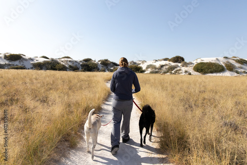 Photography Woman walks dogs on trail in White Sands National Park