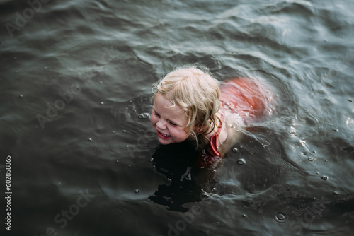 Looking down at happy child swimming in lake
