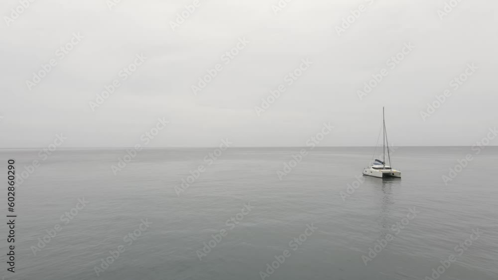 Boat or yacht stranded on the calm sea. Cloudy day. Mysterious film shot. Boat or yacht stranded on the calm sea. Cloudy day. Mysterious film shot.