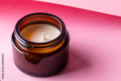 Aroma candle on pink background. Fragrance candle close up and abstract. Zen and relaxed lifestyle.
