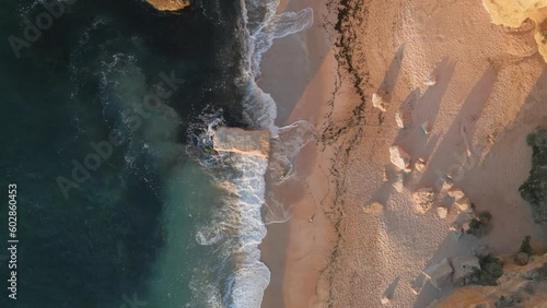 Top down view of a beach below the high cliffs of Praia da Marinha in Portugal.