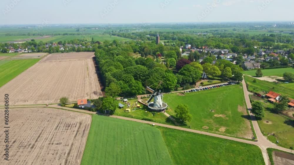 Jib up of classic windmill with spinning sails in a beautiful Dutch landscape Jib up of classic windmill with spinning sails in a beautiful Dutch landscape