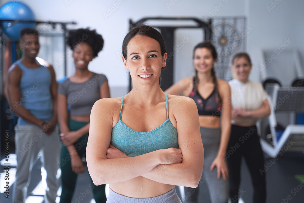 Confident woman posing with arms crossed in front of the group in the gym. Sport concept. Confident woman posing with arms crossed in front of the group in the gym. Sport concept.