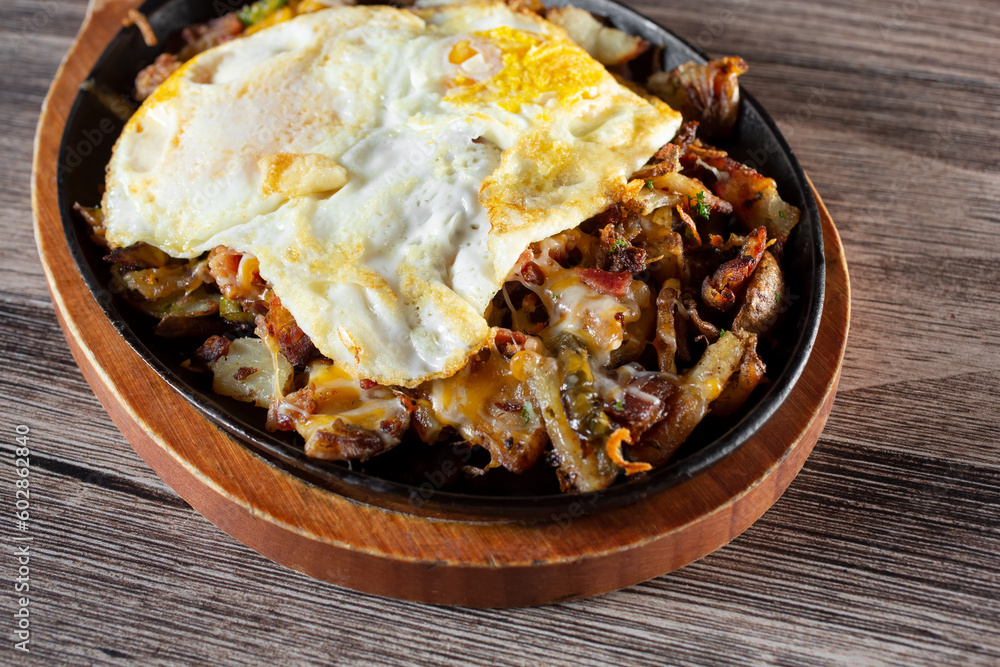 A view of a loaded potato breakfast on a skillet. A view of a loaded potato breakfast on a skillet.