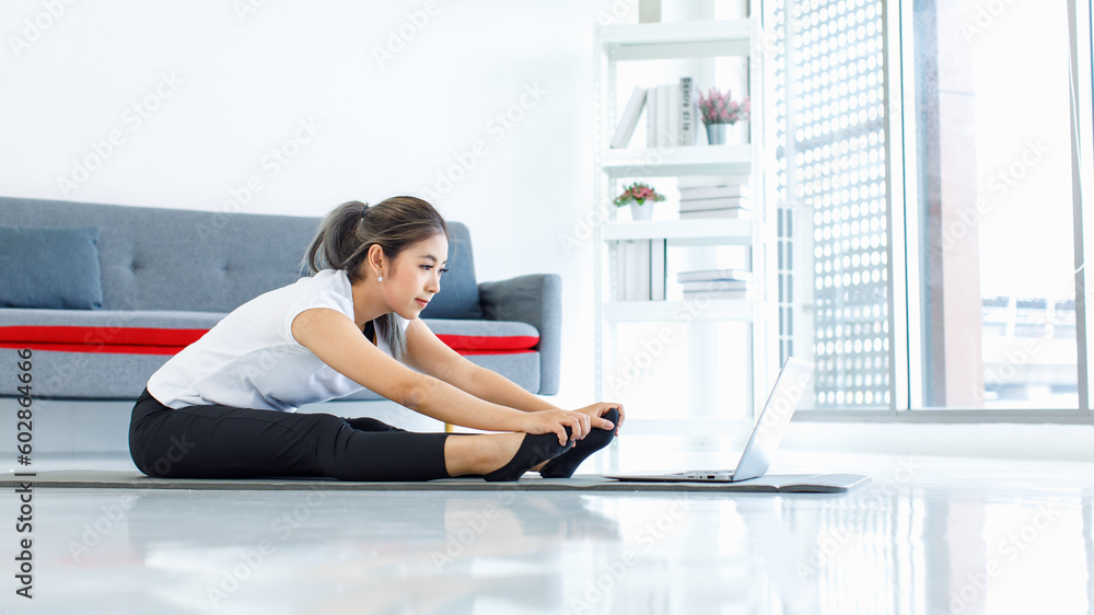 Obraz premium Portrait shot Asian beautiful healthy fit slim sexy female sporty athlete model in sportswear and leggings sitting stretching arms smiling look at camera ready for workout exercising via online video