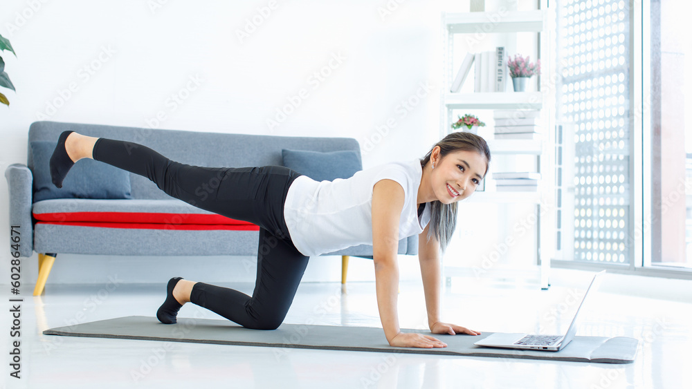 Asian healthy fit slim sexy female sporty athlete model friend in sportwear and leggings laying down planking on yoga mat together watching online streaming workout lesson via laptop computer Asian healthy fit slim sexy female sporty athlete model friend in sportwear and leggings laying down planking on yoga mat together watching online streaming workout lesson via laptop computer