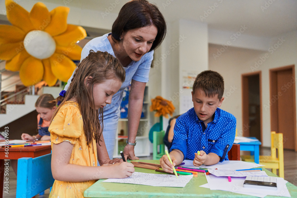 Creative kids during an art class in a daycare center or elementary school classroom drawing with female teacher. Creative kids during an art class in a daycare center or elementary school classroom drawing with female teacher.
