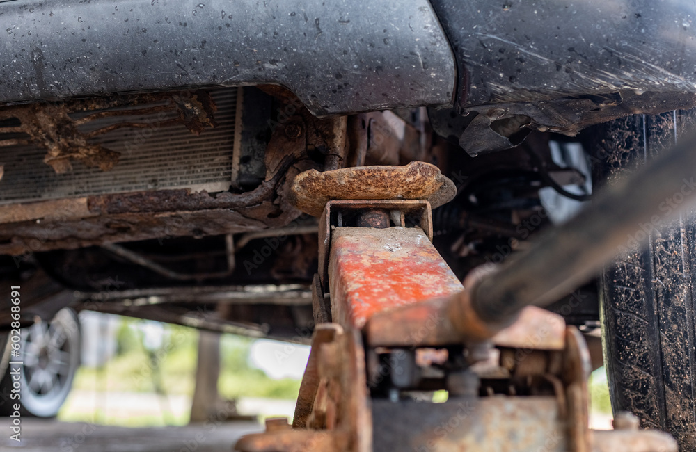 Hydraulic car jack, maintenance service car garage Car mechanic using jack to repair suspension. Automobile service. Hydraulic car jack, maintenance service car garage Car mechanic using jack to repair suspension. Automobile service.