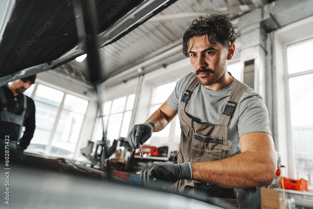 Mechanic examining car in auto car repair service center Mechanic examining car in auto car repair service center