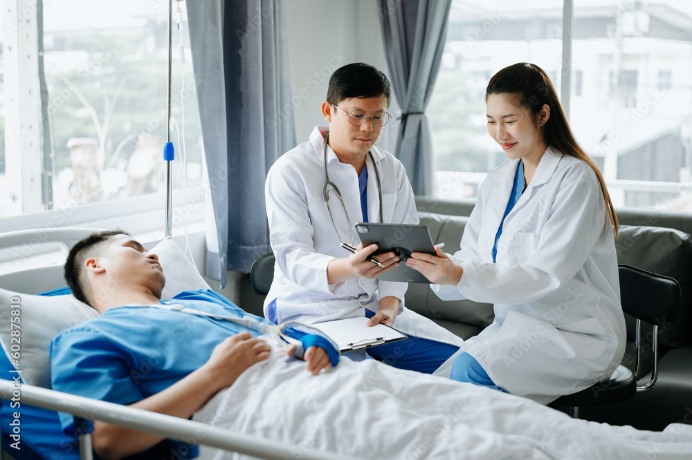 Obraz premium Two doctors talking to a patient lying in his bed with receiving saline solution in hospital .