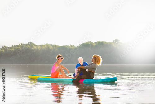 Three diverse friends enjoying their day and relaxing on SUP boards