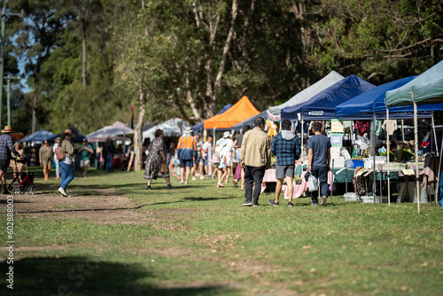 Weekend country market in a park in Australia. Family’s and people at a Farmers market selling fruit and vegetables 