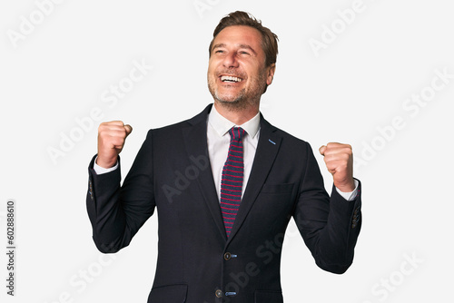 A middle-aged businessman isolated raising fist after a victory, winner concept.