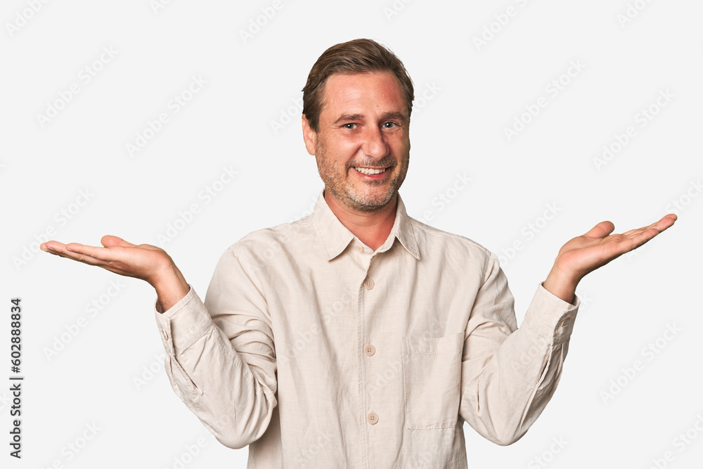 A middle-aged man isolated makes scale with arms, feels happy and confident. A middle-aged man isolated makes scale with arms, feels happy and confident.