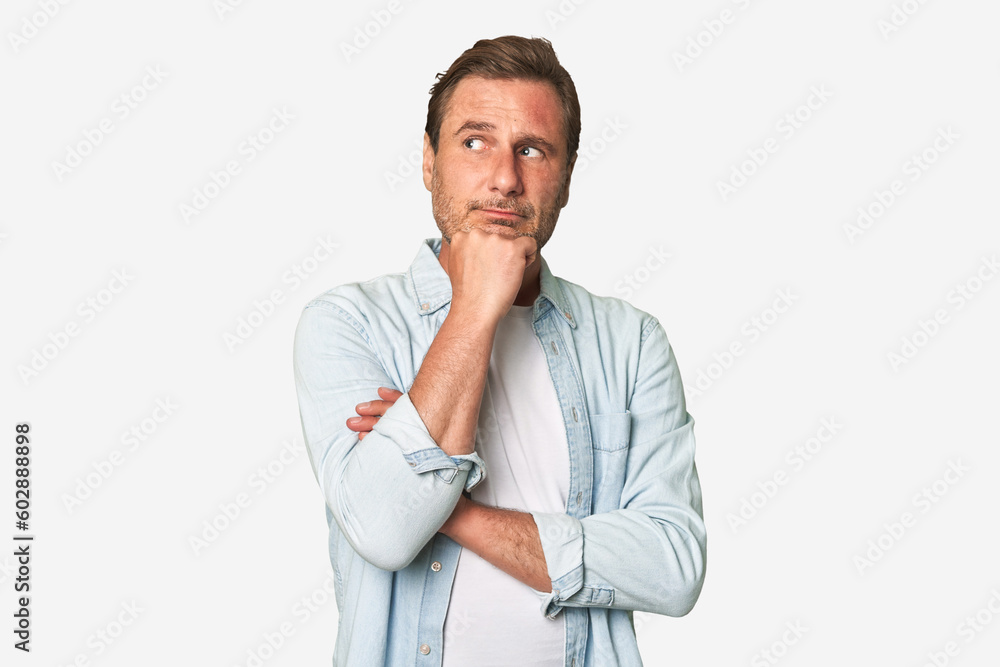 A middle-aged man isolated thinking and looking up, being reflective, contemplating, having a fantasy. A middle-aged man isolated thinking and looking up, being reflective, contemplating, having a fantasy.