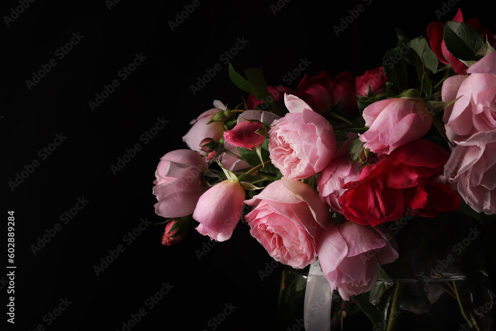 Romantiche rose antiche, fiori recisi in vaso su fondo nero, spazio per testo Romantiche rose antiche, fiori recisi in vaso su fondo nero, spazio per testo
