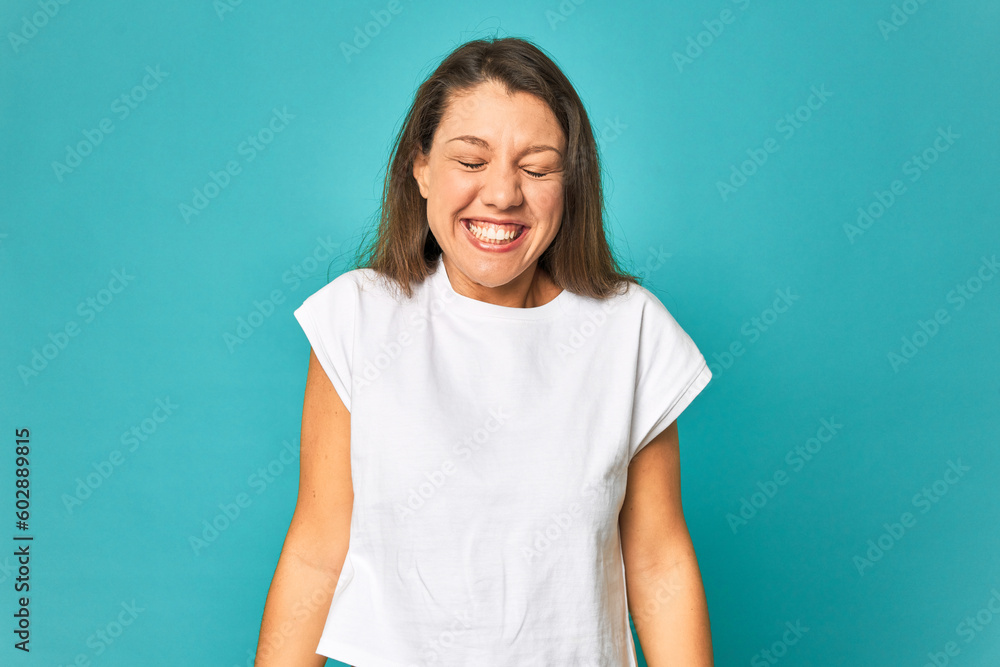 A young caucasian woman isolated laughs and closes eyes, feels relaxed and happy. A young caucasian woman isolated laughs and closes eyes, feels relaxed and happy.