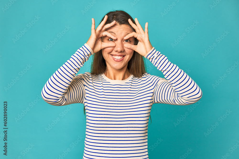 A young caucasian woman isolated showing okay sign over eyes A young caucasian woman isolated showing okay sign over eyes