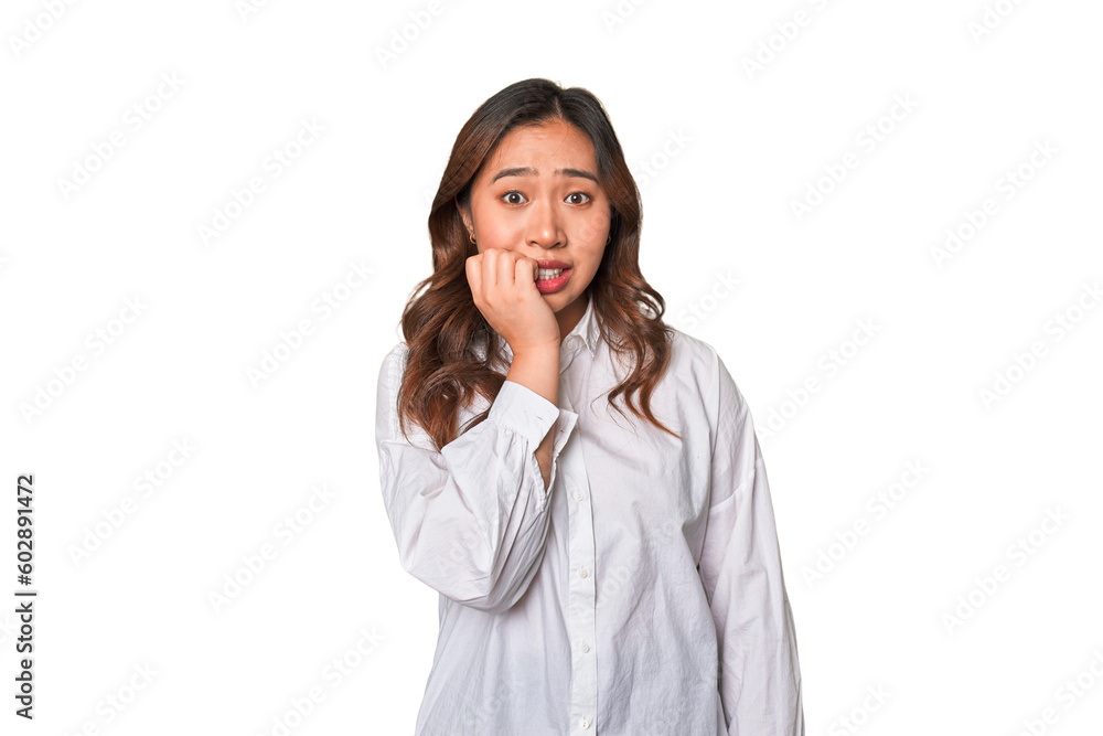 A young chinese woman biting fingernails, nervous and very anxious. A young chinese woman biting fingernails, nervous and very anxious.