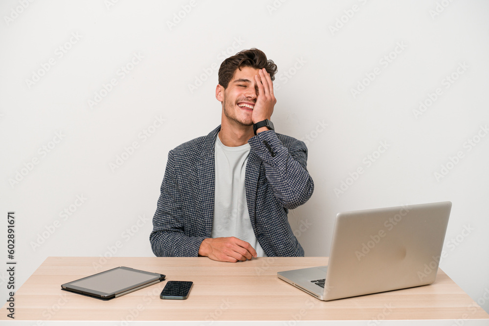 Young entrepreneur man working with a laptop isolated laughing happy, carefree, natural emotion. Young entrepreneur man working with a laptop isolated laughing happy, carefree, natural emotion.