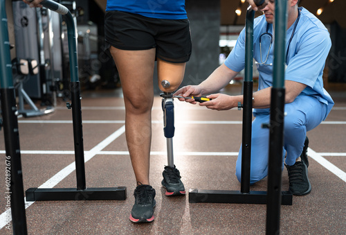 Assisted male physiotherapist take care woman with prosthetic leg and use screwdriver repair to prosthetic leg	