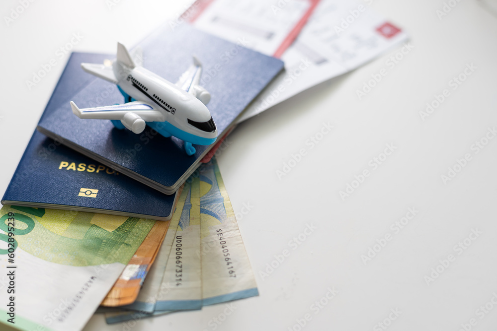 Air tickets, passports, money and toy plane on table - obrazy, fototapety, plakaty 
