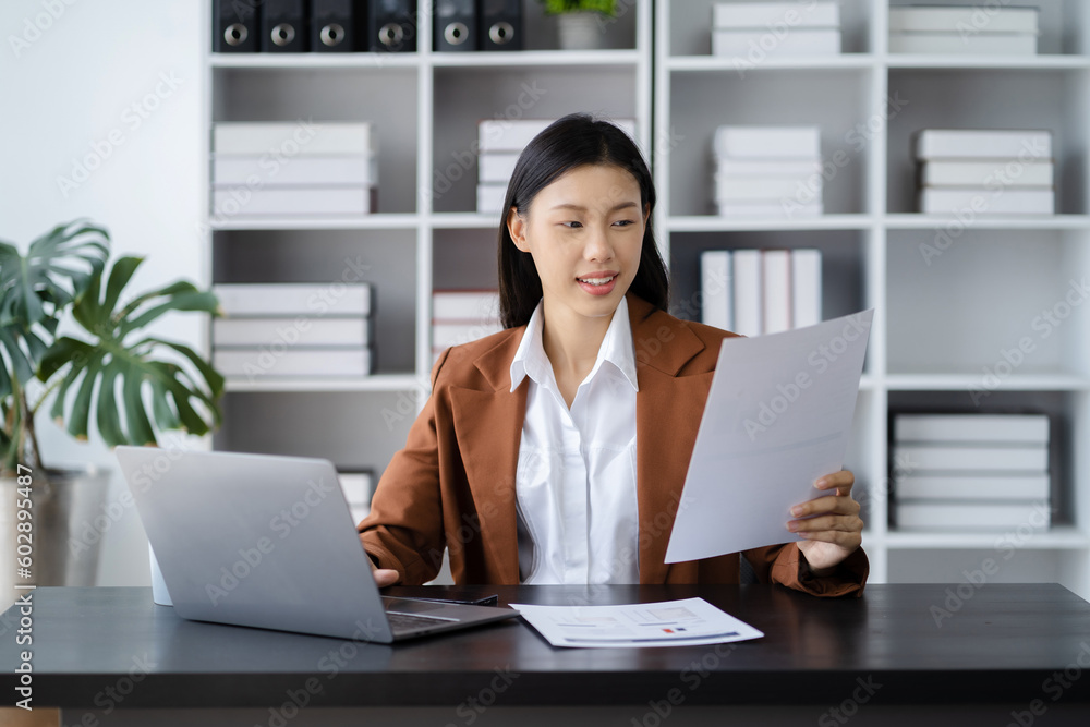 Business women calculate and analyzing graph document financial with laptop in office. Business women calculate and analyzing graph document financial with laptop in office.