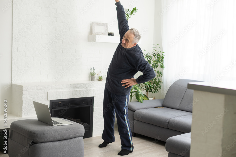 Fototapeta premium Mature aged man watching video training tutorial online, vlogging and blogging at home on lockdown