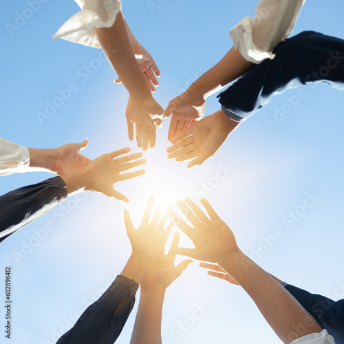 Below hands circle  business people or teamwork by sky background for support  solidarity or goal. Men  women and group with helping hand in air for collaboration  motivation or outdoor team building