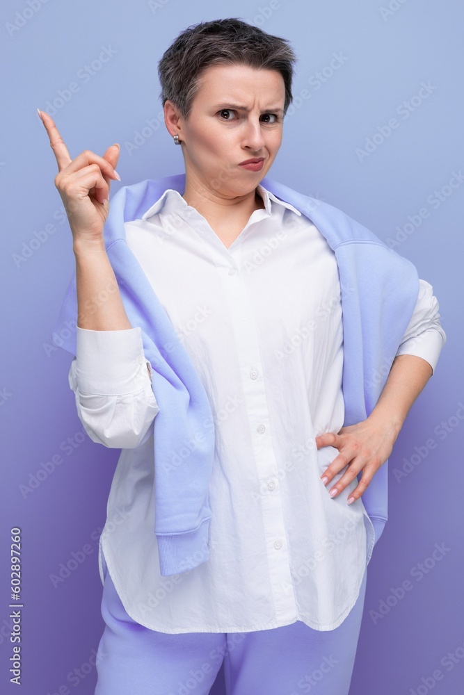 indignant surprised brunette woman with short haircut in white shirt on studio background indignant surprised brunette woman with short haircut in white shirt on studio background