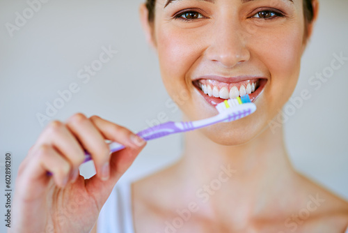 Toothpaste  toothbrush and woman brushing teeth in bathroom for health  happiness and wellness in morning. Girl  portrait and cleaning mouth or healthcare  dental care or oral hygiene  smile or home