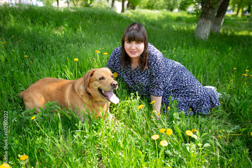 Young beautiful woman and her golden retriever dog having fun in summer