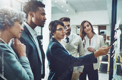 Business people  planning or woman writing on board for brainstorming or speaking of solution or team ideas. Group goals  sticky note or group meeting with leadership for problem solving together