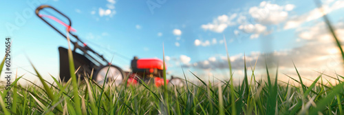 Photos Modern red lawn mower on a bright sunny summers day in profile view 3d render