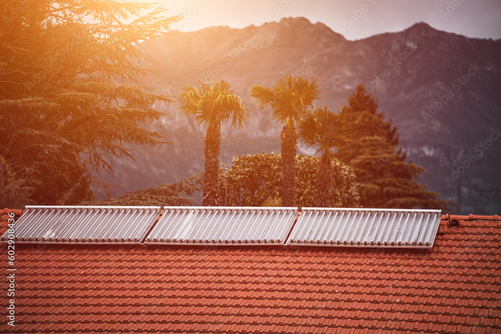Water solar collector on a red metal roof. Solar thermal and solar ...