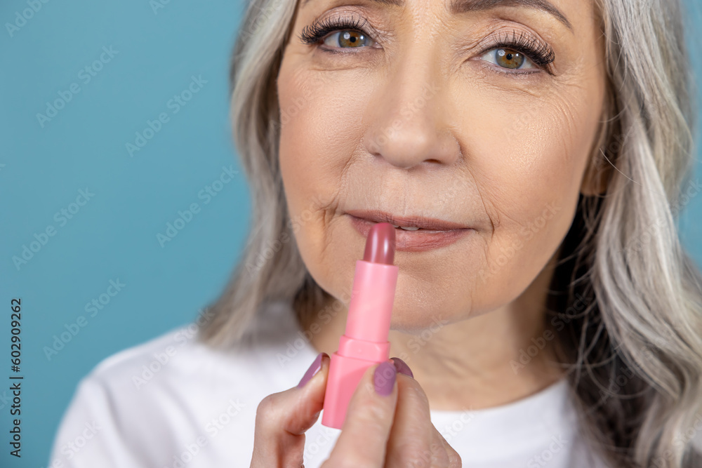 Beautiful aging woman with lipstick doing makeup Beautiful aging woman with lipstick doing makeup