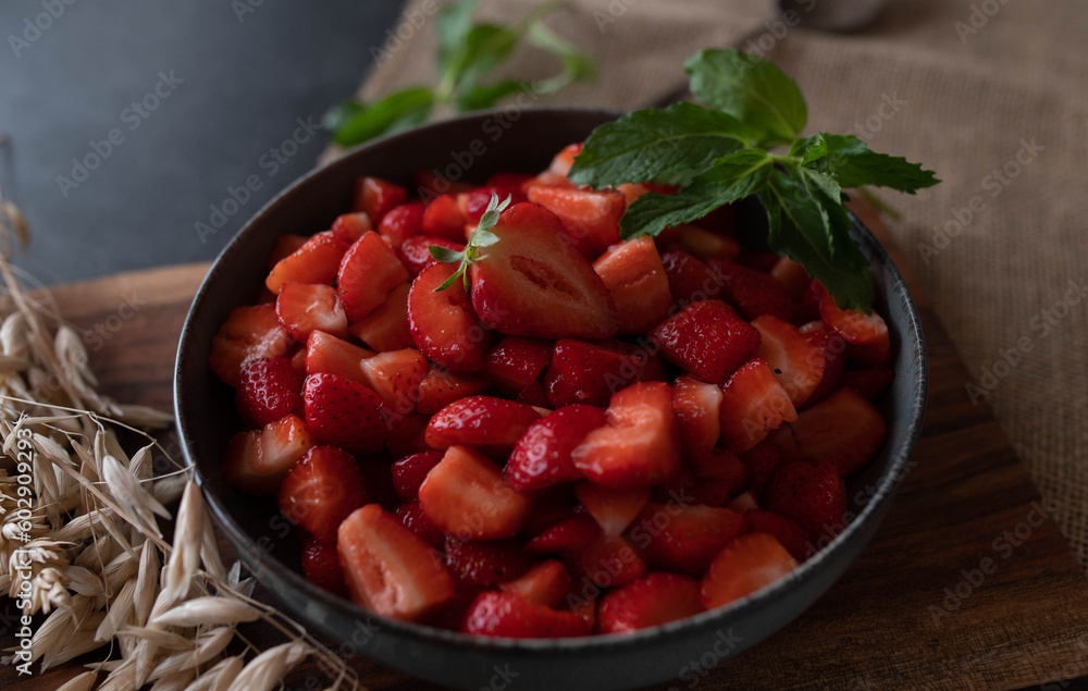 Bowl with marinated and chopped strawberries on rustic background Bowl with marinated and chopped strawberries on rustic background
