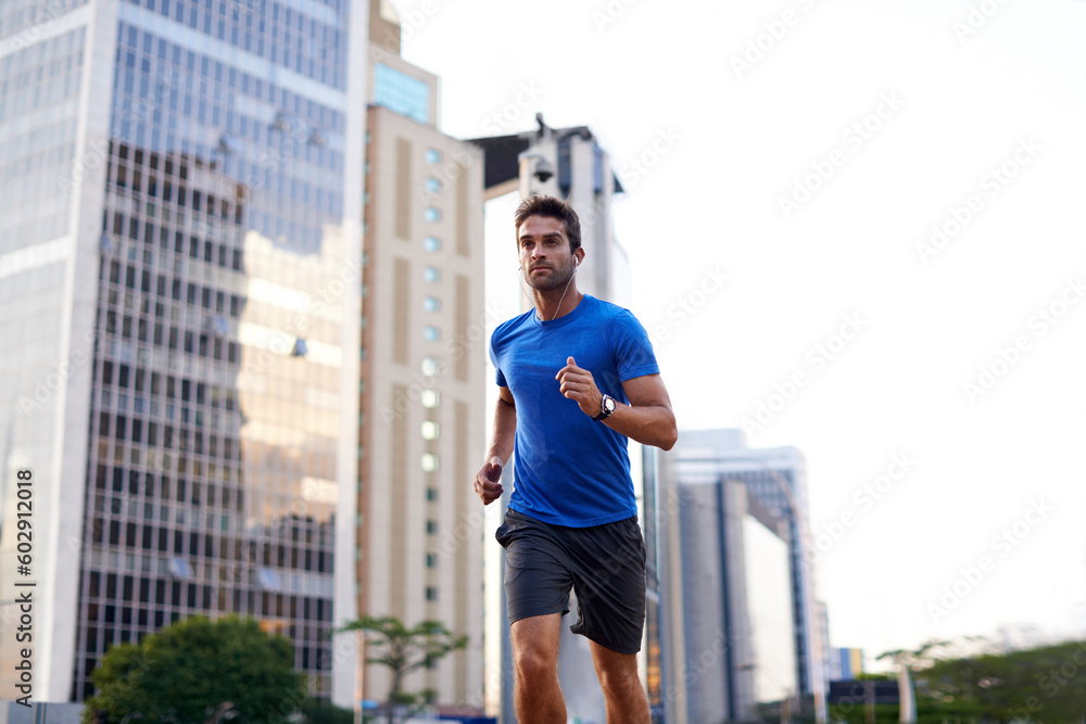 Sports, exercise and man running in the city for health, wellness or training for a marathon. Fitness, runner and male athlete doing an outdoor cardio workout for endurance or speed in an urban town.