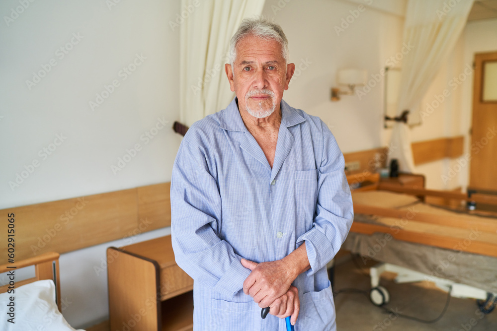Fototapeta premium Elderly man with walking cane standing in nursing home