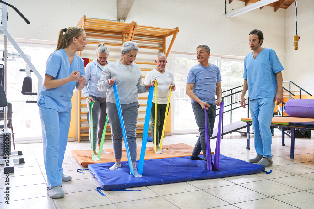 Therapists assisting senior patients doing workout at nursing home