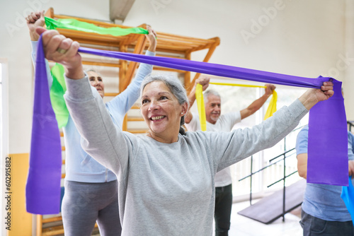 Elderly woman and men exercising with stretch bands at rehab center
