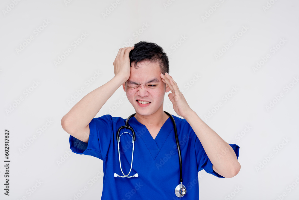 A disappointed and frustrated young medical student or intern or nurse posing with his hand on his temple and looking troubled. Isolated on a white background. A disappointed and frustrated young medical student or intern or nurse posing with his hand on his temple and looking troubled. Isolated on a white background.
