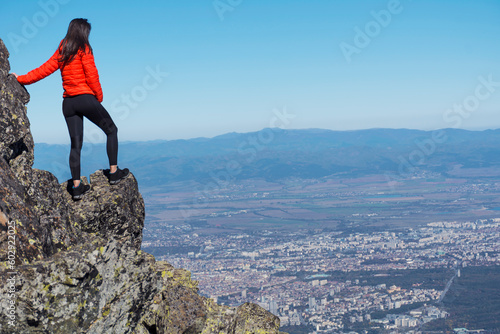 Woman standing on a rocks high in the autumn mountain above the city of Sofia. Vitosha mountain, ,Bulgaria