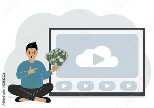 A man holds paper banknotes in his hand, next to a computer with a video. Freelancer, earning money, working on the Internet, training, coaching, business, remote work.