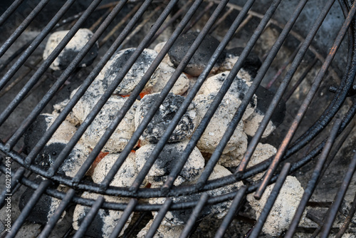 Rozpalony grill ogrodowy z brykietem pokrytym białym popiolem gotowy do pieczenia potrawy  © Paweł Kacperek