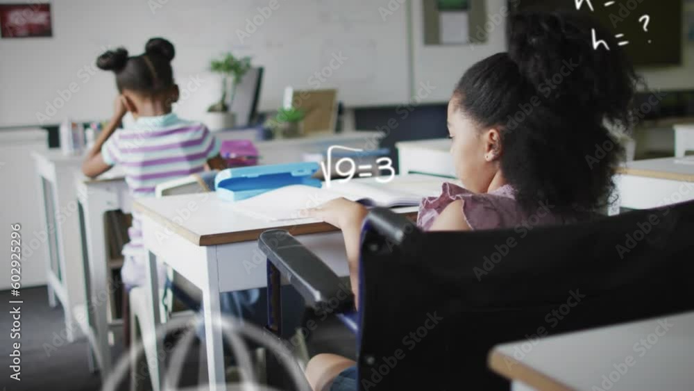 Animation of maths calculations over happy biracial schoolgirl in wheelchair at desk in class Animation of maths calculations over happy biracial schoolgirl in wheelchair at desk in class
