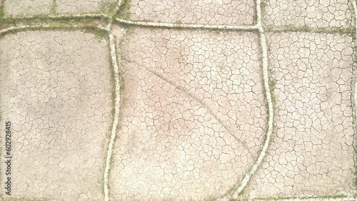 flying over very dry farmland lowering toward one field (top-down drone shot)