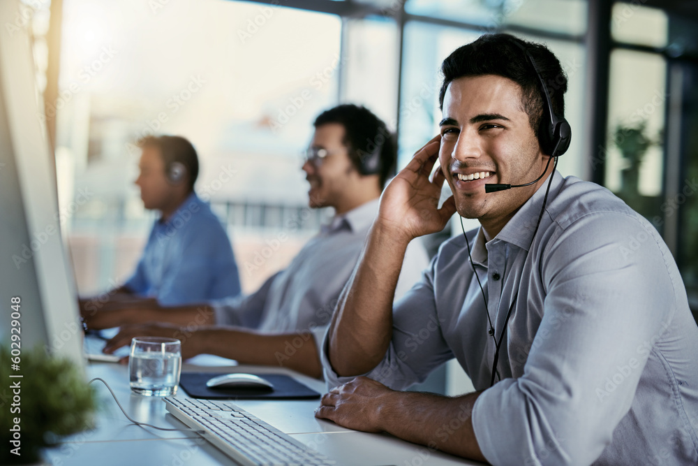 Callcenter agent, smile and man in office consulting with advice, help and happiness at desk. Happy phone call, conversation and service, customer support consultant speaking on headset at crm agency Callcenter agent, smile and man in office consulting with advice, help and happiness at desk. Happy phone call, conversation and service, customer support consultant speaking on headset at crm agency